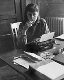 Carson McCullers sitting at a desk with a typewriter